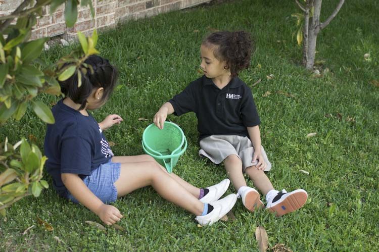 Children gardening together outdoors in the Heritage Montessori play area