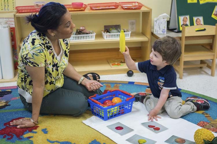 A teacher giving a child one-on-one time with a Montessori lesson